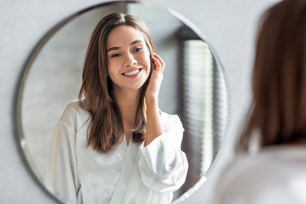 Woman admires her clear complexion in the mirror